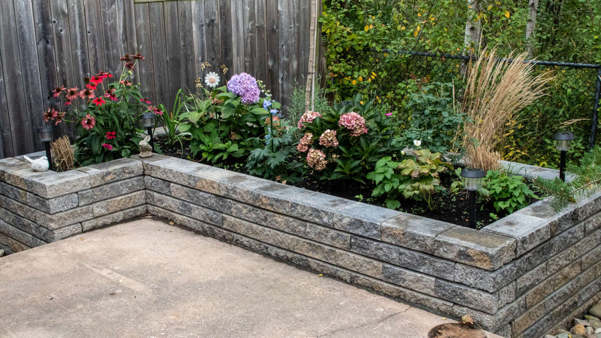 Landscaping, hardscaping and stonework project London Ontario. Stone retaining wall flower bed.